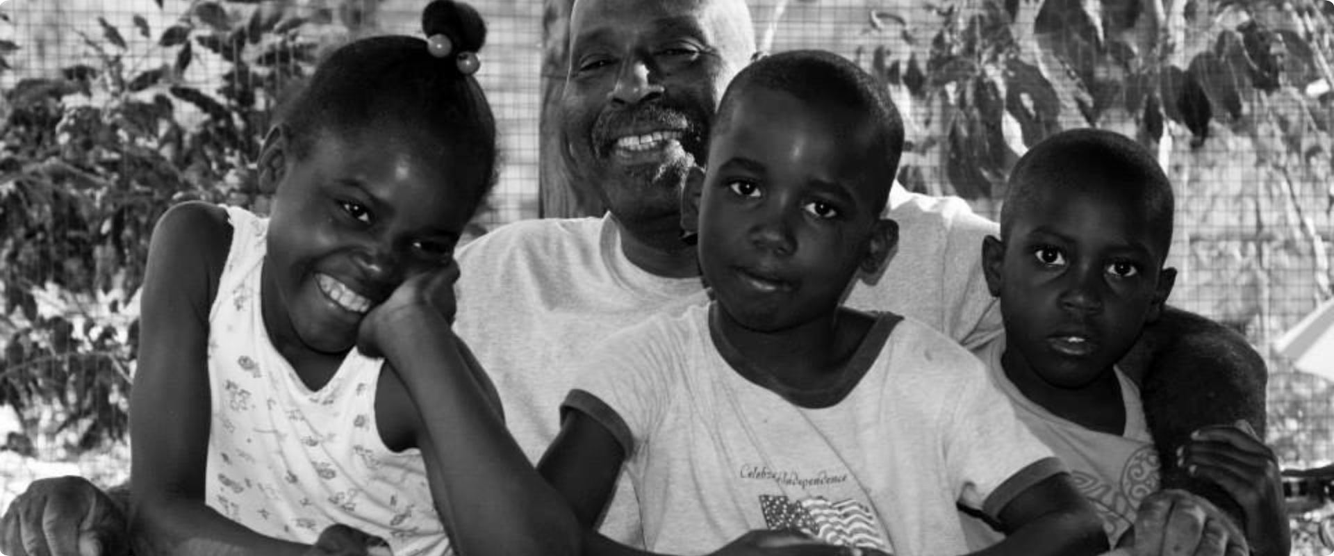 A grandfather smiling with three children in Haiti