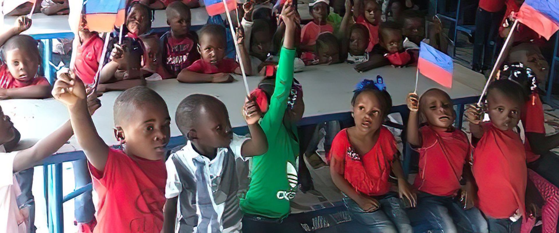 Children waving Haitian flags together at school