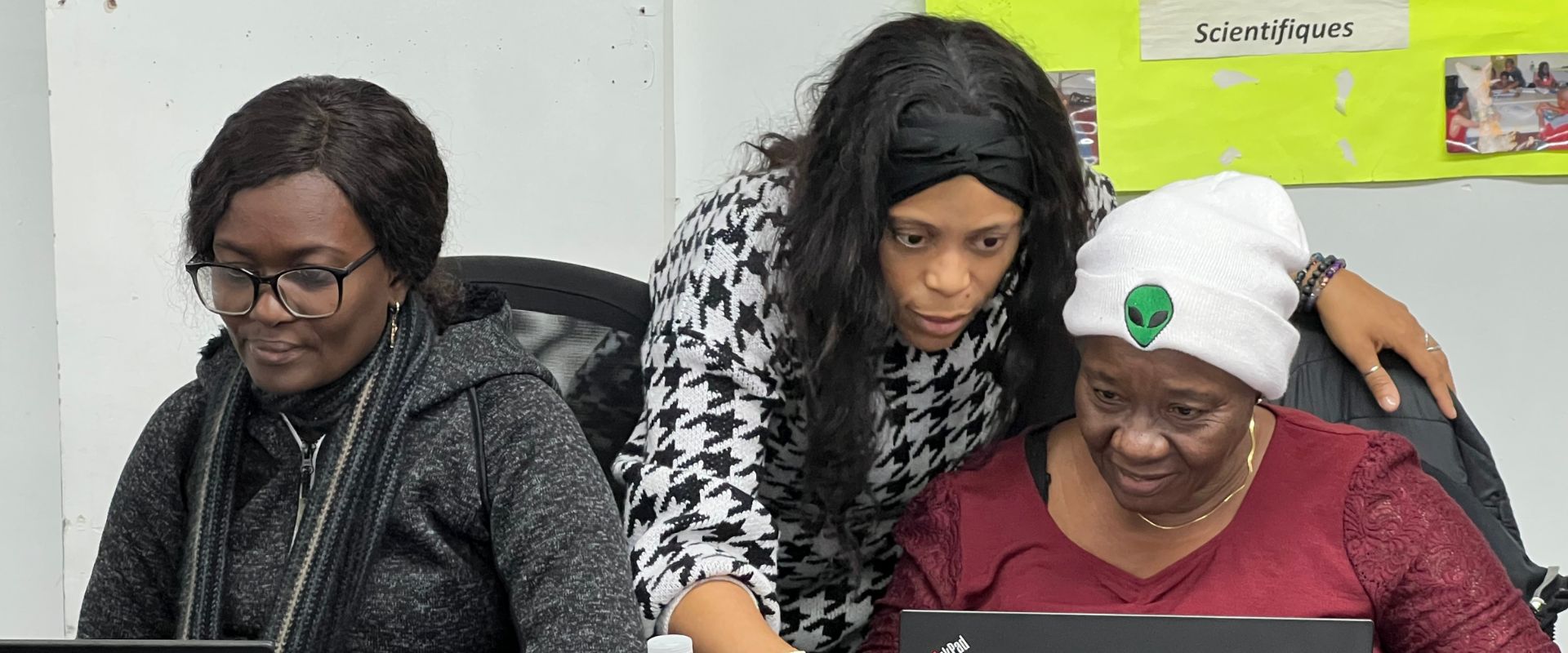 Seeking Life facilitators helping a participant on a laptop